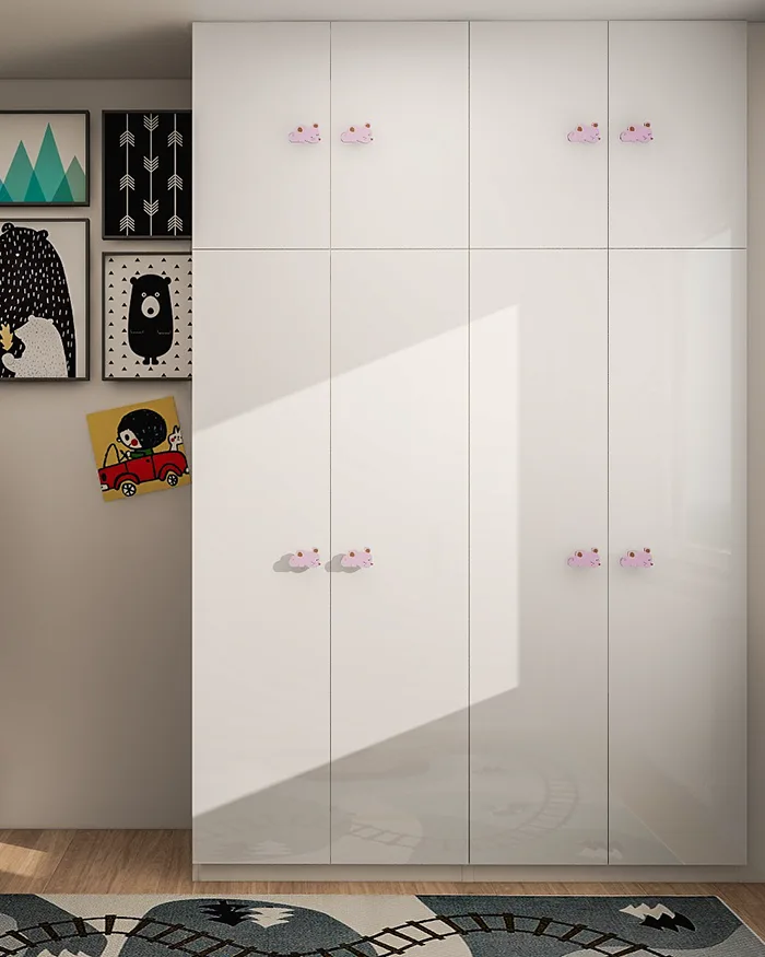 Kids room design with a large custom white wardrobe, glossy cabinet fronts and playful handles