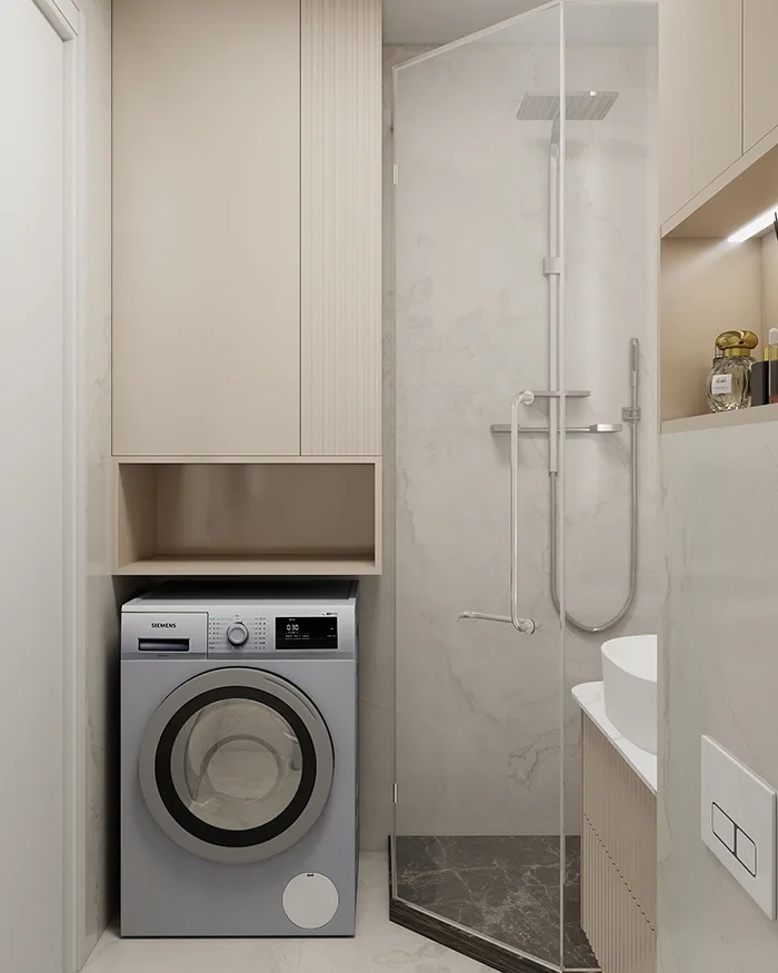 Moderno kupatilo sa ugradnim plakarom za veš mašinu, tuš kabinom i svetlim mermernim oblogama